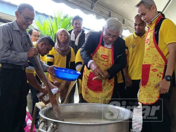 Abdul Aziz memasukkan bahan tambahan kepada bubur lambuk yang dimasak pada Program Gotong Royong Bubur Lambuk Peringkat Jabatan Pendidikan Negeri (JPN) Perak di Atrium Gemilang JPN.