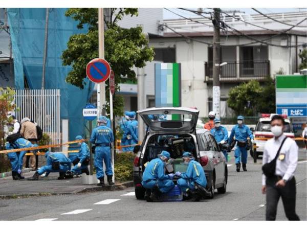 Pakar forensik menjalan siasatan di tempat kejadian. - Foto AFP