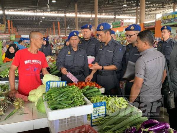 Azanizam (tiga dari kanan) memeriksa gerai peniaga di RTC, Tunjong, di sini sempena Operasi Bersepadu yang di jalankan KPDNHEP Kelantan. 