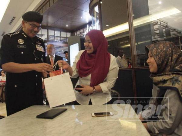 Mazlan bermesra dengan pengunjung ketika membuat lawatan di Menara Berkembar Kuala Lumpur (KLCC) selepas merasmikan Kempen Op Selamat 15, hari ini. - FOTO ZAHID IZZANI