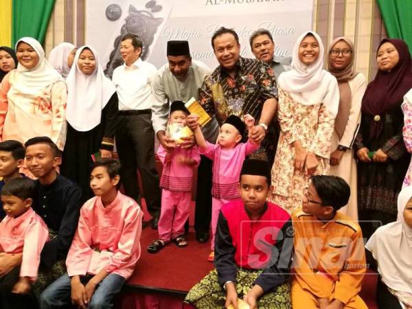 Hasni (empat dari kanan) bergambar bersama anak-anak yatim Kampung Sri Rusa dalam majlis berbuka di Hotel Avillion, semalam.