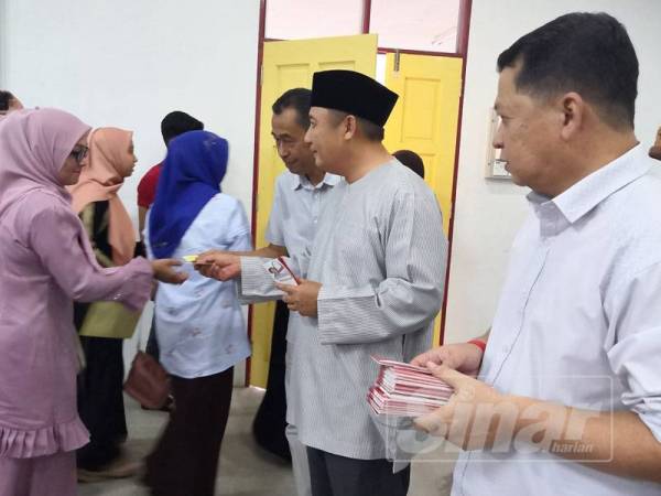 Ahmad Jazlan menyampaikan sumbangan zakat kepada pelajar asnaf di Pusat Transformasi Ilmu, Kampung Cherang di sini.