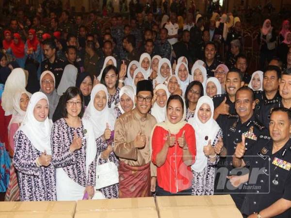 Ahmad Faizal bersama isterinya, Datin Seri Nomee Ashikin Mohammed Radzi (tengah) bergambar bersama PDRM yang dihadiri Ketua Polis Perak, Datuk Razarudin Husain (tiga dari kanan) pada Majlis Pembungkusan dan Penyerahan Juadah Raya Aidilfitri kepada pasukan beruniform 2019 hari ini.
