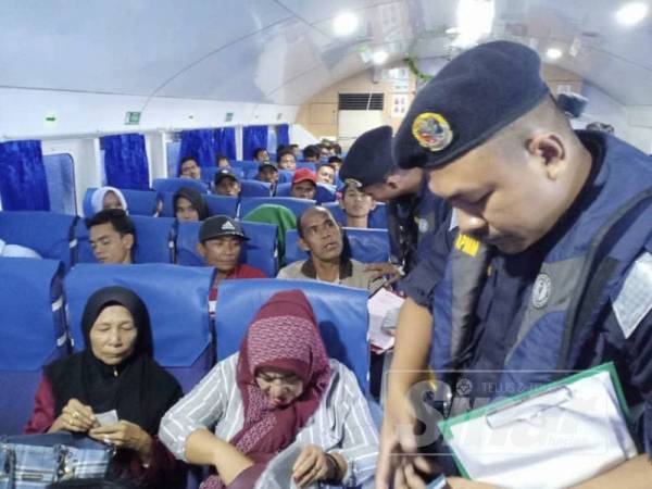 Anggota APMM ketika membuat pemeriksaan dokumen terhadap penumpang feri dalam Ops Pagar Laut yang sedang dijalankan.