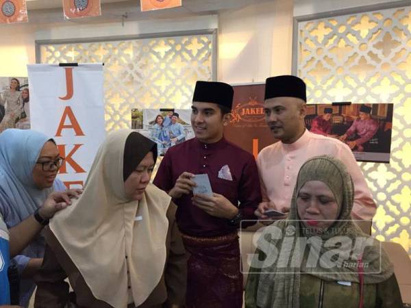 Syed Saddiq bersama Mohd Fuad (kanan) ketika menyampaikan sumbangan kepada 50 asnaf fakir miskin yang terdiri daripada orang kelainan upaya (OKU) dan miskin bandar di Jakel Mall hari ini.
