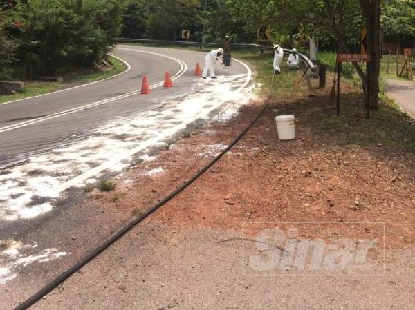 Anggota bomba sedang menjalankan kerja membersihkan tumpahan bahan kimia di atas jalan di Kampung Paya Rumput, Masjid Tanah.