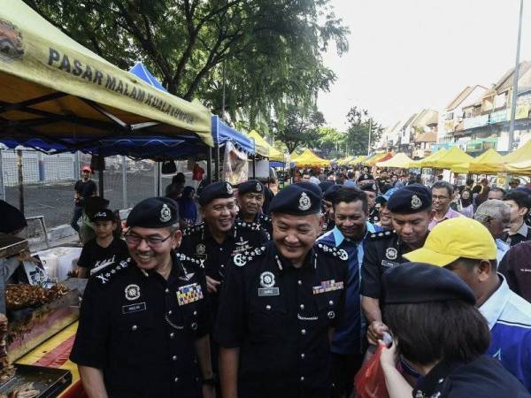 Ketua Polis Negara Datuk Seri Abdul Hamid Bador (tengah) beramah mesra serta mengedarkan cenderamata kepada perniaga berupa risalah tentang keselamatan pada Program Kepolisan Berprofil Tinggi sempena Bulan Ramadan dan Hari Raya Aidilfitri di Bazar Ramadan Taman Tun Dr Ismail hari ini. Foto: Bernama