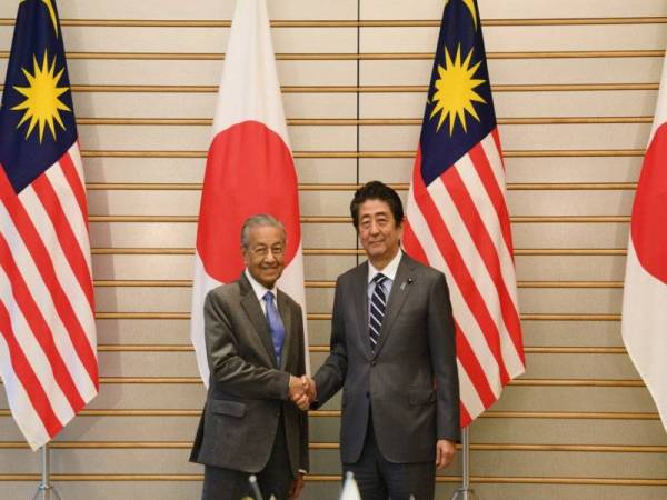 Perdana Menteri Tun Dr Mahathir Mohamad (kiri) disambut oleh rakan sejawatnya Shinzo Abe ketika hadir pada mesyuarat dua hala di Sori Kantei hari ini. - Foto Bernama 