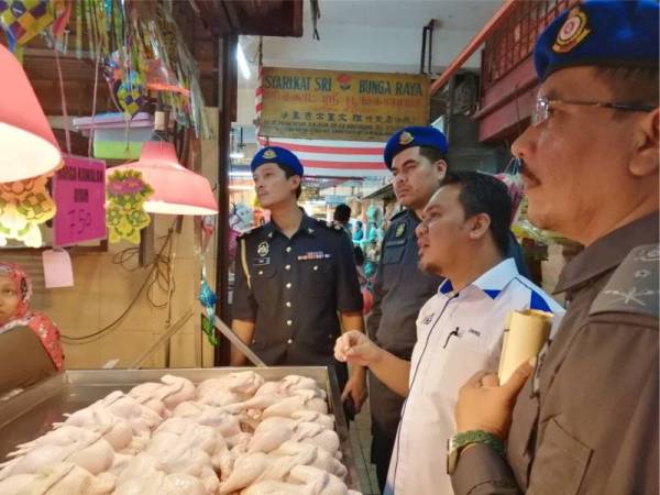 Muhamad Zikril memantau harga ayam yang disenarai sebagai barang kawalan SHMMP di Pasar Awam Kajang semalam.