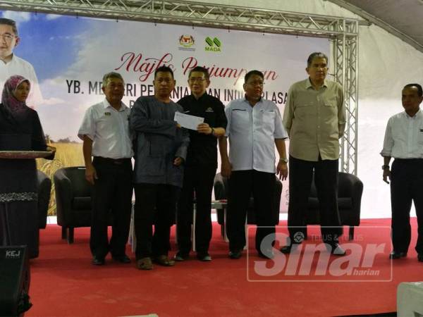 Salahuddin memberikan sumbangan kepada pesawah ketika majlis perjumpaan Menteri Pertanian dan Industri Asas Tani bersama peladang MADA di pekarangan Masjid Sultanah Haminah Kampung Banggol Besi semalam.