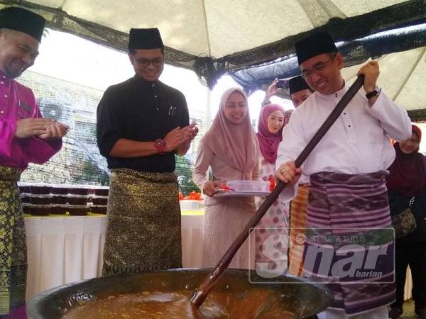 Adly ketika mengacau dodol pada majlis ramah mesra Amanah Finance House Berhad di Bukit Baru di sini hari ini.