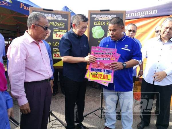 Salahuddin menyampaikan gimik harga 'Happy Hour' di Pasar Tani Datin Halimah sempena pelancaran Program Jualan Jimat Belanja Aidilfitri di sini hari ini.