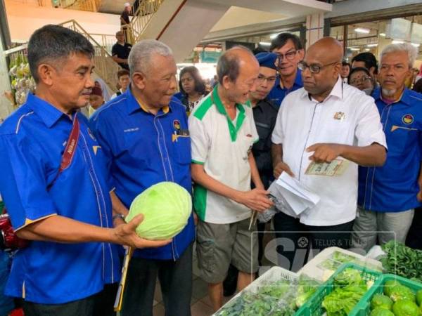 Ramakrishnan (kanan) ketika membuat pemeriksaan di salah satu ruang jualan di Pasar Besar Larkin, di sini hari ini.