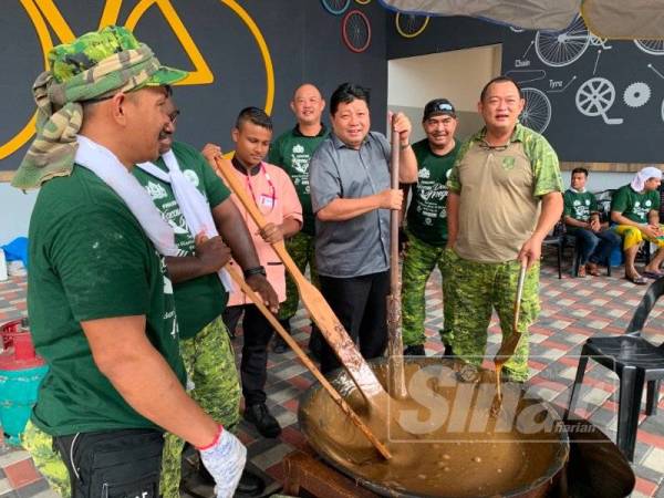 Mazlan (tiga,kanan) bersama peserta ketika mengacau dodol sempena program berkenaan, hari ini.