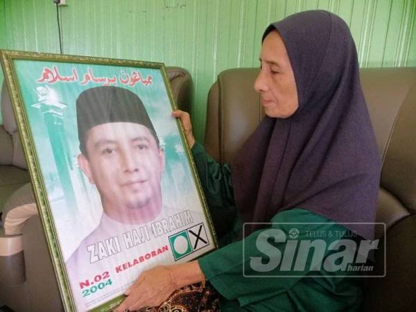 Che Zaharah menatap gambar arwah Mohd Zaki ketika awal penglibatannya dalam politik menjadi calon PAS di DUN Kelaboran pada tahun 2004.