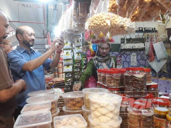 Mukhriz (kiri) turut merakamkan gambar kenangan semasa sesi 'walkabout'nya di Pekan Rabu Alor Setar hari ini.