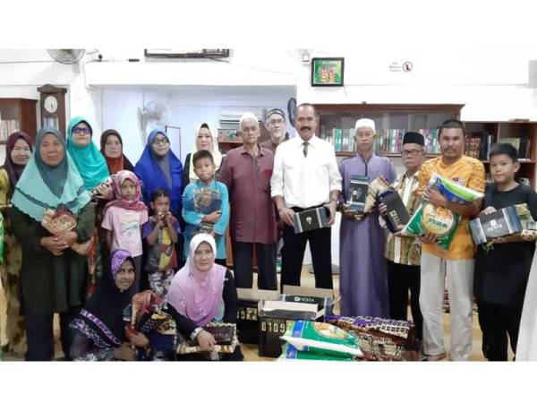 Abu Bakar ketika menyampaikan sumbangan kepada mereka yang memerlukan di Kampung Sungai Sireh Tambahan semalam.