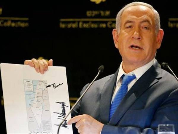 Netanyahu dengan angkuh menunjukkan peta menunjukkan Bukit Golan sebagai wilayah Israel yang turut tertera tandatangan Trump.
