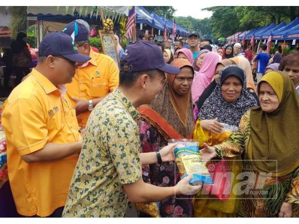 Fahmi (dua dari kiri) beramah mesra bersama pengunjung pada Majlis Pelancaran Program Jualan Jimat Belanja Aidilfitri di Pasar Tani Bukit Angkasa disini.