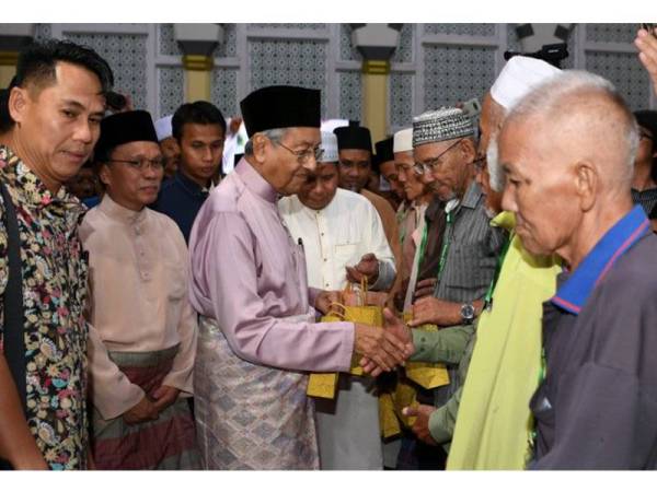 Perdana Menteri Tun Dr Mahathir Mohamad diiringi Ketua Menteri Sabah Datuk Seri Mohd Shafie Apdal (dua, kiri) ketika menyampaikan sumbangan kepada seramai 20 golongan Asnaf pada majlis Iftar bersama Perdana Menteri di Masjid Bandaraya di sini hari ini.