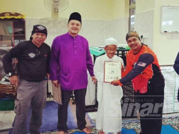 Tamizi (kanan) menyerahkan sijil kepada Imam Masjid Paya Besar di Surau Bukit Pak Kuning baru-baru ini.