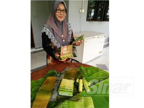 Norzin menunjukkan burasak dan lepat lueh yang dihasilkan di rumahnya di Pekan Nanas.