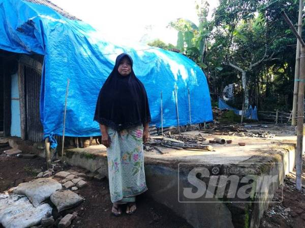 Muslihun berdiri di tepi tapak rumahnya yang musnah selepas gempa pertama melanda kampung itu, Julai lalu.