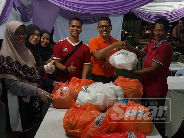 Mohd.Zahir menyerahkan makanan yang dikumpulkan kepada NGO terlibat.