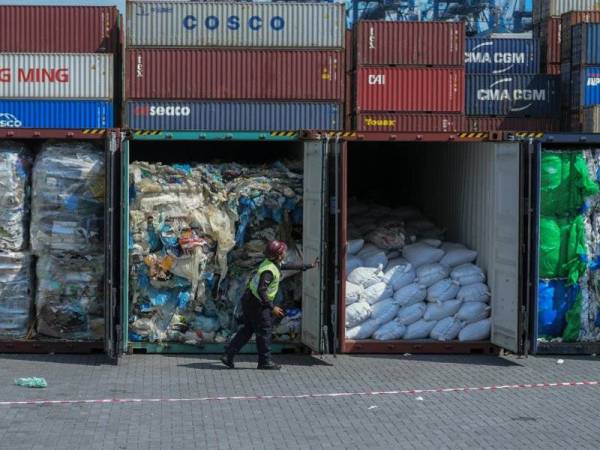 Pekerja kontraktor membuka kontena yang mengandungi bahan buangan ketika liputan menghantar semula sisa plastik kepada pengeksport di Pelabuhan Barat baru-baru ini. - FOTO BERNAMA