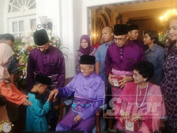 Seorang kanak-kanak bersalaman dengan Dr Mahathir sambil diperhatikan Dr Siti Hasmah dan Mukhriz pada Majlis Rumah Terbuka Aidilfitri Menteri Besar Kedah dan keluarga di Seri Mentaloon, di sini hari ini.