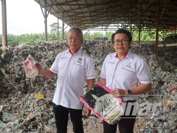 Wong Tack (kiri) dan ADUN Bilut, Lee Chin Chen menunjukkan sisa plastik yang diimport dari Kanada ketika melakukan tinjauan di kawasan gudang tersebut di Karak, baru-baru ini.