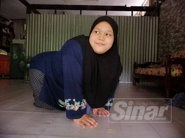 Zati Aina merangkak untuk bergerak di rumahnya di Kampung Pasir Pekan bercita-cita tinggi mahu jadi tukang jahit profesional.
