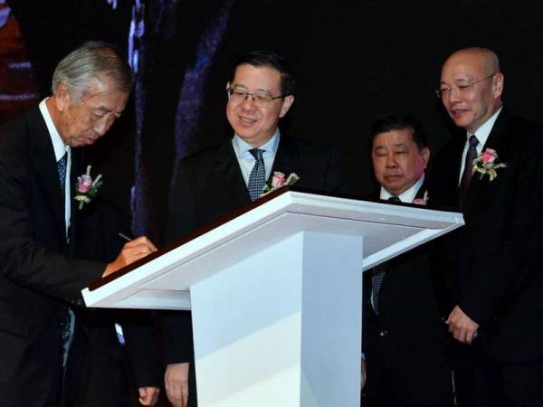 Guan Eng (dua, kiri) dan Duta Jepun ke Malaysia, Dr Makio Miyagawa (kiri) menandatangani plak selepas menyaksikan majlis menandatangani perjanjian pemegang saham antara Join Overseas Infrastructure Investment Corporation (JOIN) dengan TASCO Berhad pada majlis hari ini. Foto: Bernama