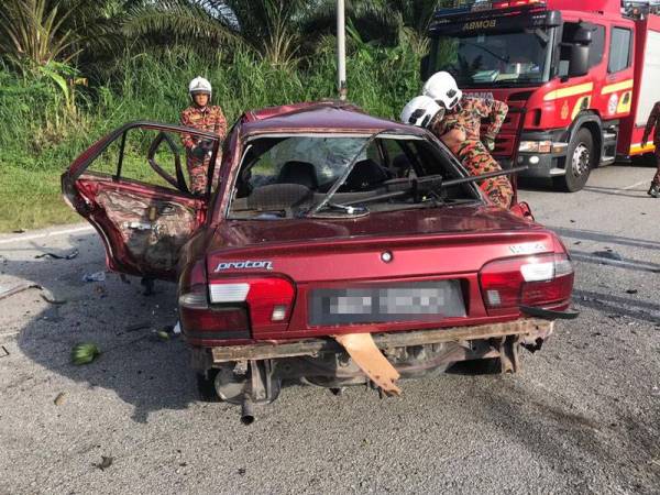 Anggota bomba membantu mengeluarkan mayat mangsa yang tersepit di tempat duduknya di Bidor hari ini. Foto - Jabatan Bomba dan Penyelemat Perak