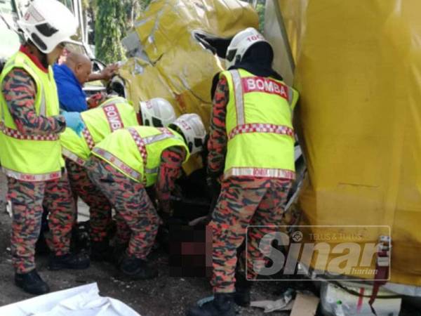 Anggota BBP Taiping berusaha mengeluarkan mangsa maut yang tersepit di bahagian tempat duduk hadapan lori kecil setelah terbabit kemalangan dengan sebuah lori kontena hari ini.