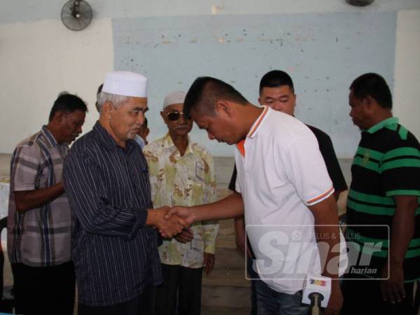 Lim Kok (kanan) bersalaman dan memohon maaf kepada Mohd Yusop (kiri) dalam satu sidang media khas di Taman Piandang Indah, Tanjung Piandang petang tadi.