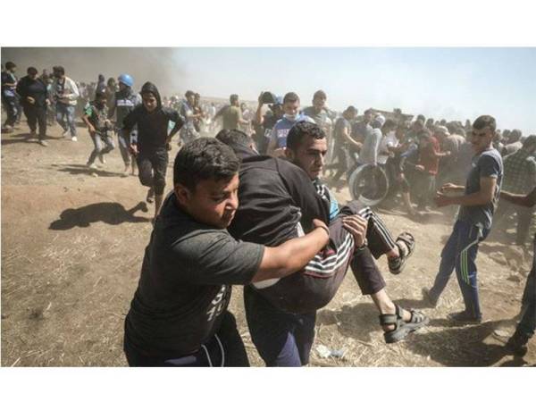 Penduduk Palestin mengangkat rakan mereka yang cedera akibat ditembak tentera Israel.