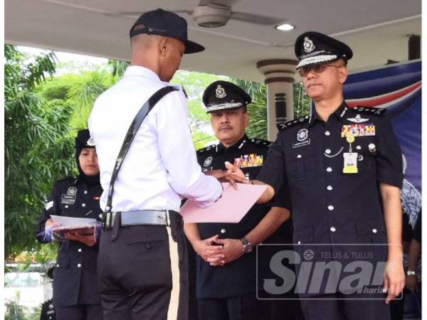 Hasanuddin (kanan) menyampaikan sijil penghargaan kepada anggotanya dalam Perhimpunan Bulanan di IPK Kelantan hari ini.