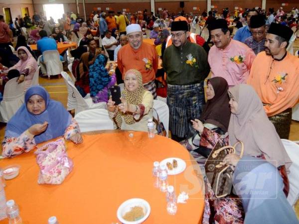 Dr Mujahid (berdiri dua, kiri) beramah mesra dengan orang ramai pada Majlis Jamuan Rahmah Aidilffitri anjuran Parti Amanah Negara Peringkat Negeri Pulau Pinang hari ini. - FOTO BERNAMA