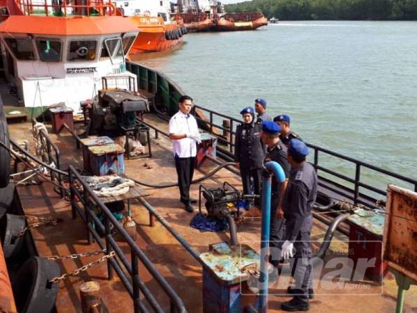 Saharuddin bersama pegawainya melihat kapal tunda yang disyaki melakukan pemindahan diesel di jeti persendirian Sungai Kuang ketika meninjau semula lokasi seebuan petang semalam.