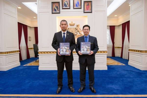 Menteri Besar Johor, Datuk Dr Sahruddin Jamal (kiri) dan Kamaruzzaman menunjukkan naskhah Buku Laporan JCorp 2018.