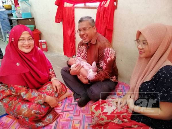 Mohamed Hanipa bersama isteri, Siti Rohani Rohmat (kiri) ketika mengunjungi Nur Aishah Iman dan bayinya di kediaman mereka di Kampung Batu 9, Jalan Changkat Jong.
