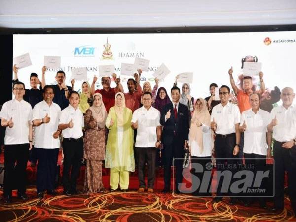 Azmin, Zuraida dan Amirudin bergambar bersama sebahagian kecil pembeli rumah Idaman Warisan yang diberikan sijil pemilikan unit yang dijangka siap selewatnya hujung tahun ini. 