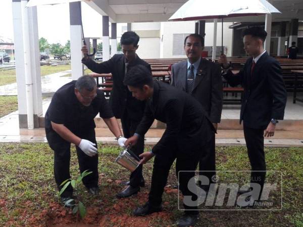 Aminolhuda (tiga dari kiri) melakukan gimik menanam pokok ketika merasmikan pelancaran operasi SMK Pengerang Utama semalam.
