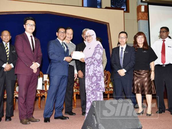 Ahmad Faizal menyampaikan peruntukan kepada wakil sekolah.