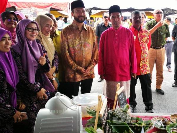 Mukhriz (empat dari kiri) bersama Zamri (lima dari kiri) ketika meninjau gerai makanan dan pameran yang disediakan di majlis Rumah Terbuka Aidilfitri ADUN Suka Menanti.