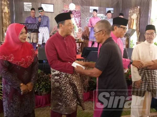 Mohamad Yasid (dua dari kiri) mengiringi Abdul Rashid (tiga dari kiri) menyampaikan duit raya kepada penerima pada Majlis Mesra MPK di Taman Pengkalan Baru, semalam 