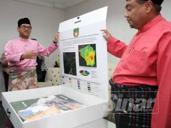 Ahmad Faizal (kiri) bersama Yahanis menunjukkan pelan pembangunan projek Perak Agrovalley yang akan dibangunkan di Lenggong.