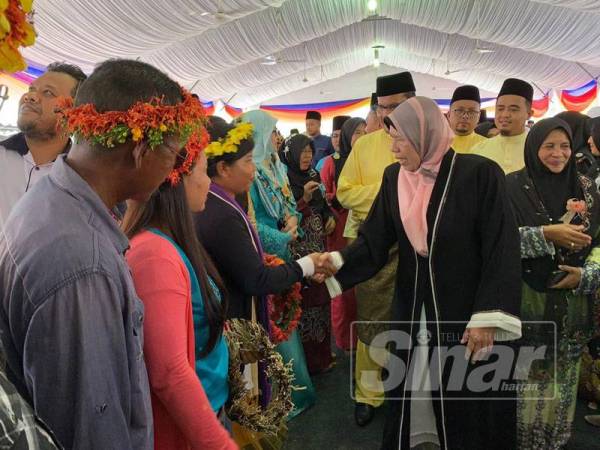 Zuraida (kanan) bersalam dengan masyarakat orang asli dari Kuala Betis yang turut menyerikan majlis tersebut.