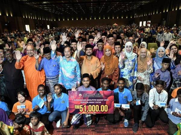 Menteri Di Jabatan Perdana Menteri Datuk Seri Dr Mujahid Yusof Rawa (tengah) bersama golongan anak-anak yatim terdiri daripada pelbagai kaum pada Majlis Sambutan Aidilfitri anjuran Majlis Agama Islam Wilayah Persekutuan (MAIWP) di Pusat Pameran dan Perdagangan Antarabangsa Malaysia (MITEC) hari ini. -Foto Bernama 